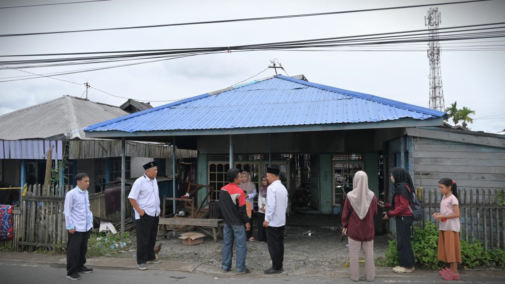 Perwakilan UIN Antasari saat meninjau kondisi rumah yang terbakar (Foto:Humas)