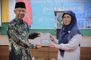 Prof. Dr. H. Akh. Fauzi Aseri, M.A. saat menyerahkan buku kepada Rektor UIN Antasari (Foto:Humas/Haitami)