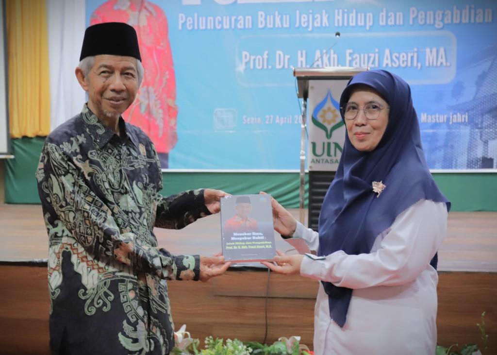Prof. Dr. H. Akh. Fauzi Aseri, M.A. saat menyerahkan buku kepada Rektor UIN Antasari (Foto:Humas/Haitami)