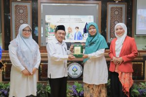 Dr. Muhdi, M.Ag. saat menyerahkan plakat kenang-kenangan kepada Plt. Dekan FK UIN Suka (Foto:Humas/Rudy Hr)