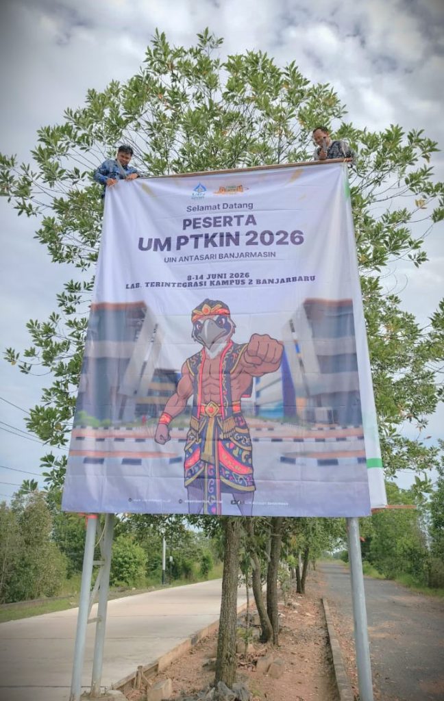 Fajrianor, M.Pd. dan Neco Erlin Pradana, S.Pd. saat bertugas memasangkan spanduk (Foto:Panitia)