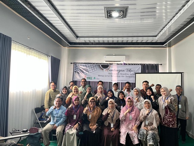 Foto bersama berlatar spanduk.