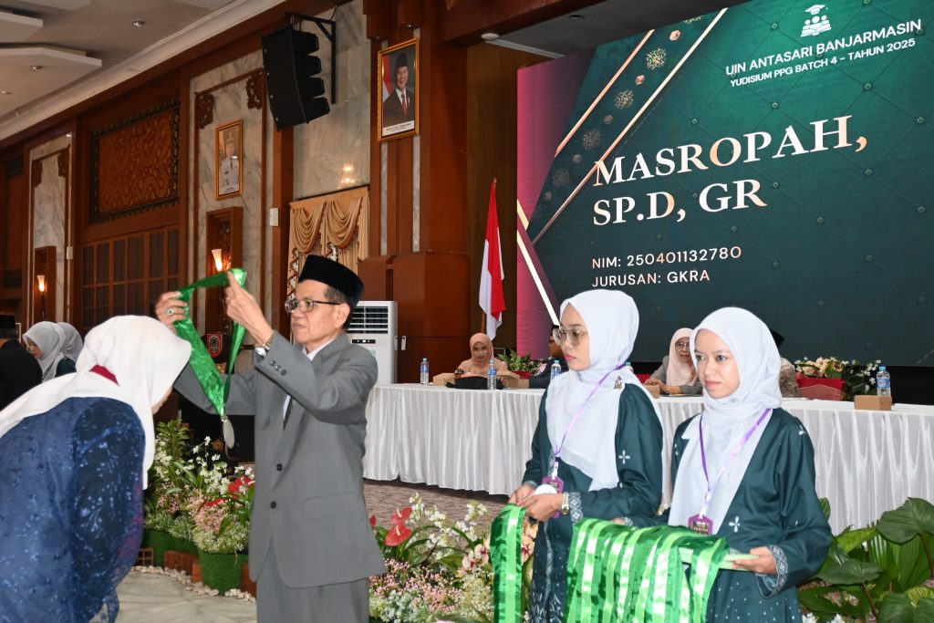 Kaprodi PPG Drs. H. Murdan, M.Ag. saat mengalungkan tanda alumni.