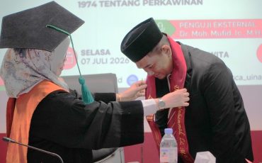 Rektor Prof. Dr. Hj. Nida Mufidah, M.Pd. saat mengalungkan tanda lulus ujian (Foto:Humas/Neco E.P.)