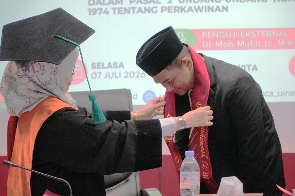 Rektor Prof. Dr. Hj. Nida Mufidah, M.Pd. saat mengalungkan tanda lulus ujian (Foto:Humas/Neco E.P.)