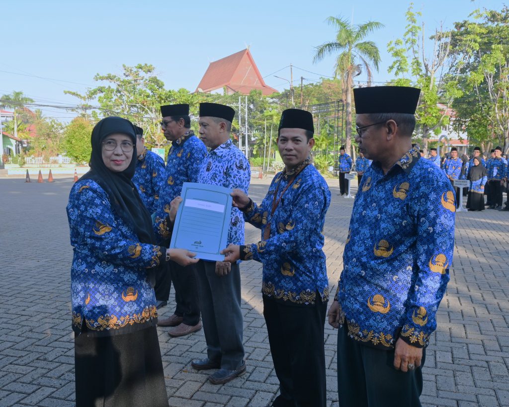 Rektor saat menyerahkan SK kenaikan pangkat kepada Guzali, S.A.P. (Foto:Humas/Jamal Ripani)