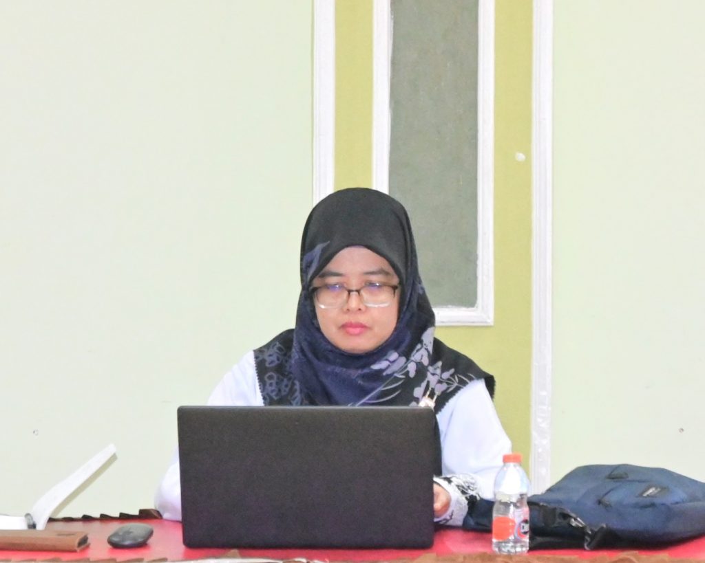 Mufidatun Nisa, S.Th.I., M.Fil.I. saat serius memantau kelancara acara via online.