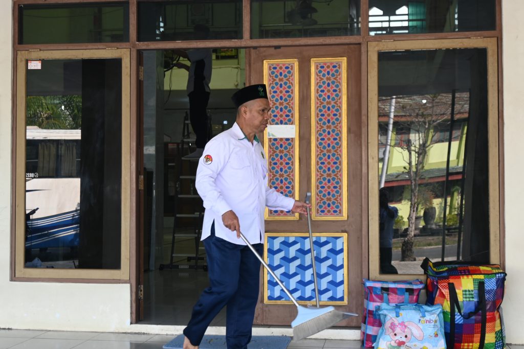 Muhammad Rusdi, S.Pd. saat bersemangat membersihkan masjid.