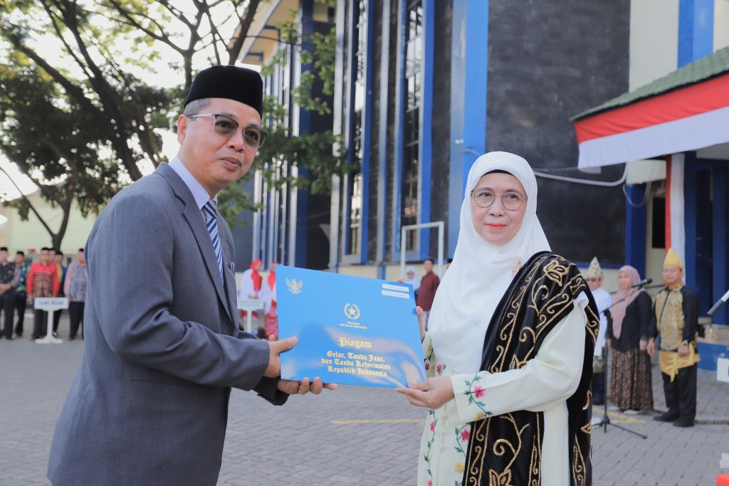 Prof. Dr. H. Akhmad Sagir, M.Ag. saat menerima Tanda Jasa