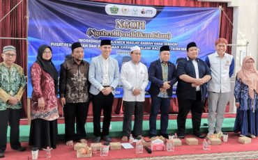 Foto bersama berlatar spanduk acara.