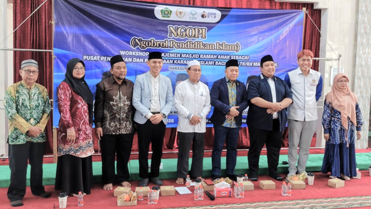 Foto bersama berlatar spanduk acara.