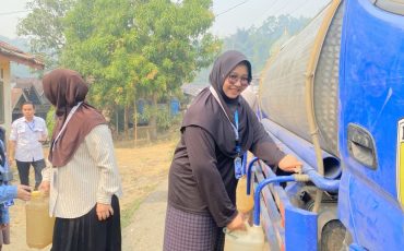 Mahasiswi KKN saat membantu penyaluran air bersih.