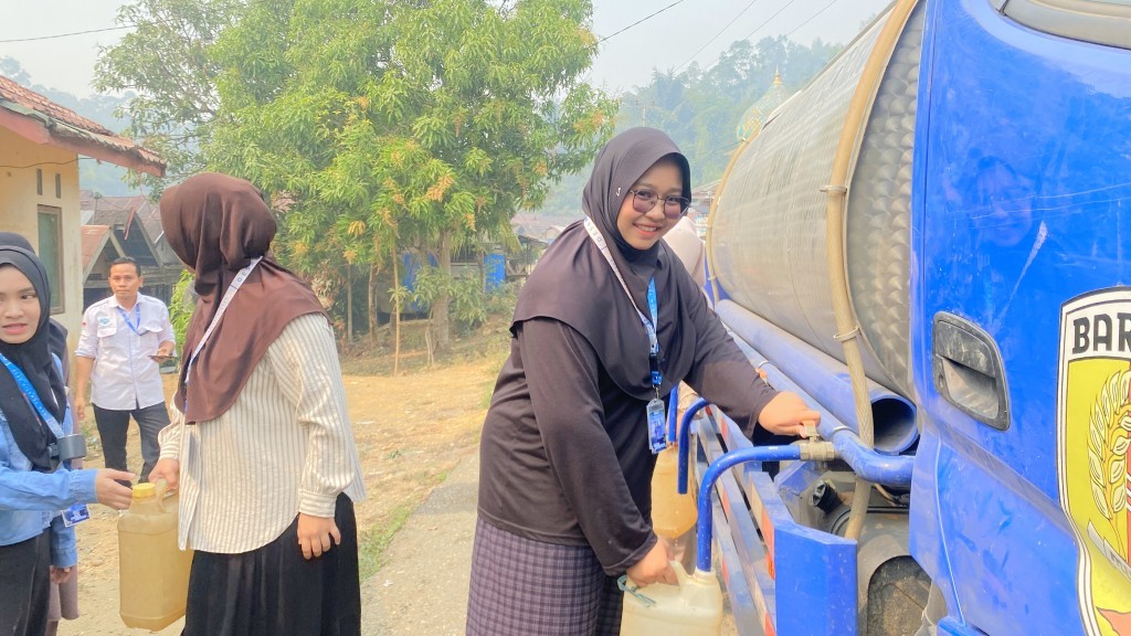 Mahasiswi KKN saat membantu penyaluran air bersih.